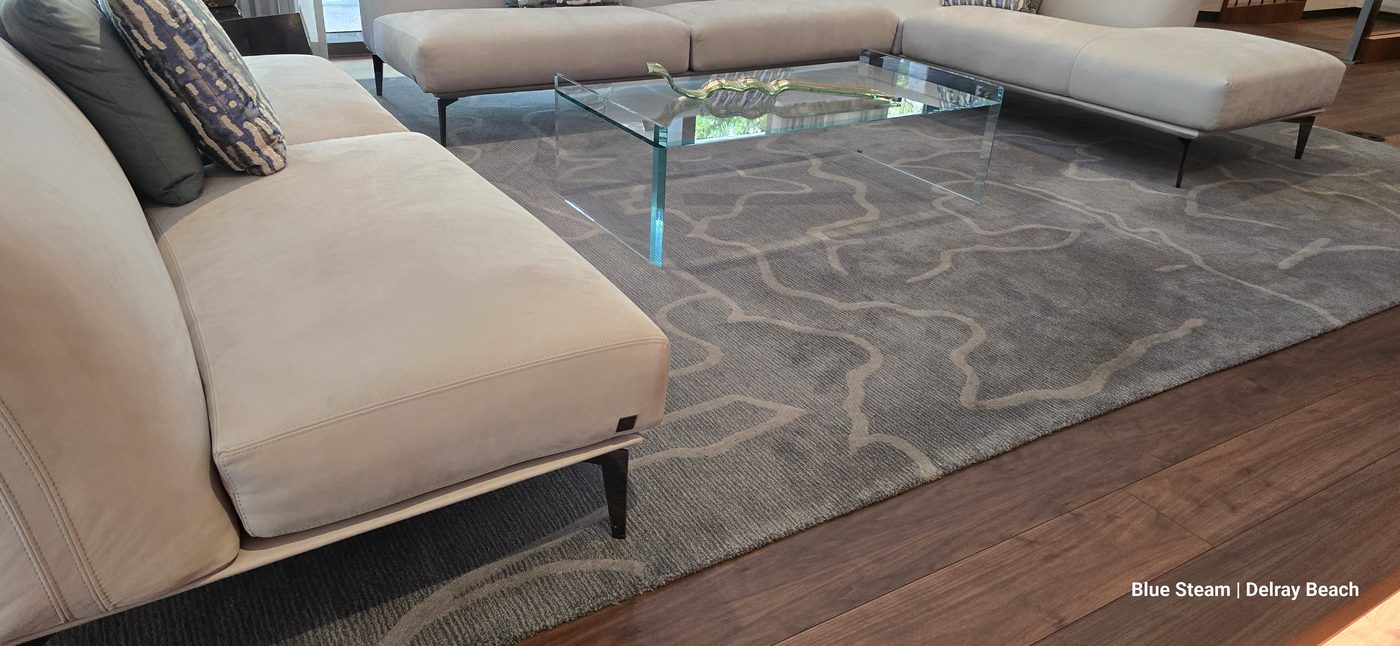 Gray patterned wool area rug and beige leather sectional in a Delray Beach living room